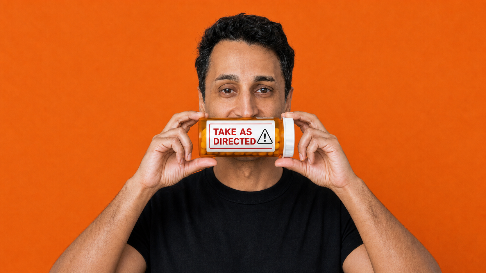 Pranay Parikh, MD holding a prescription bottle labeled Take as Directed